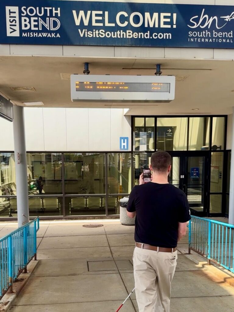 Kevin from GoodMaps approaches the “Welcome to South Bend” sign with the help of the GoodMaps app.