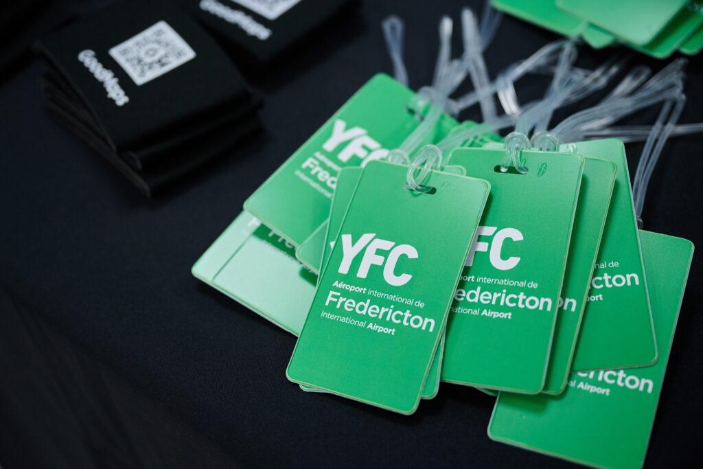 YFC lanyards are stacked on a table beside GoodMaps coffee mug sleeves.