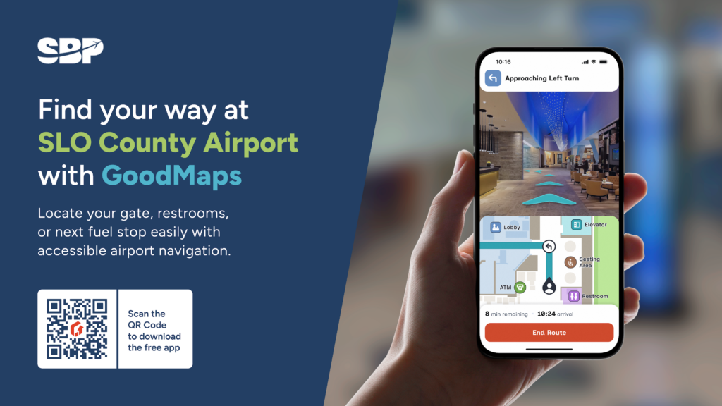 Promotional graphic for SLO County Airport showing a hand holding a smartphone with the GoodMaps indoor navigation app open, displaying turn‑by‑turn directions through the airport lobby, alongside text inviting users to locate gates, restrooms, and fuel stops with accessible navigation and a QR code to download the app.